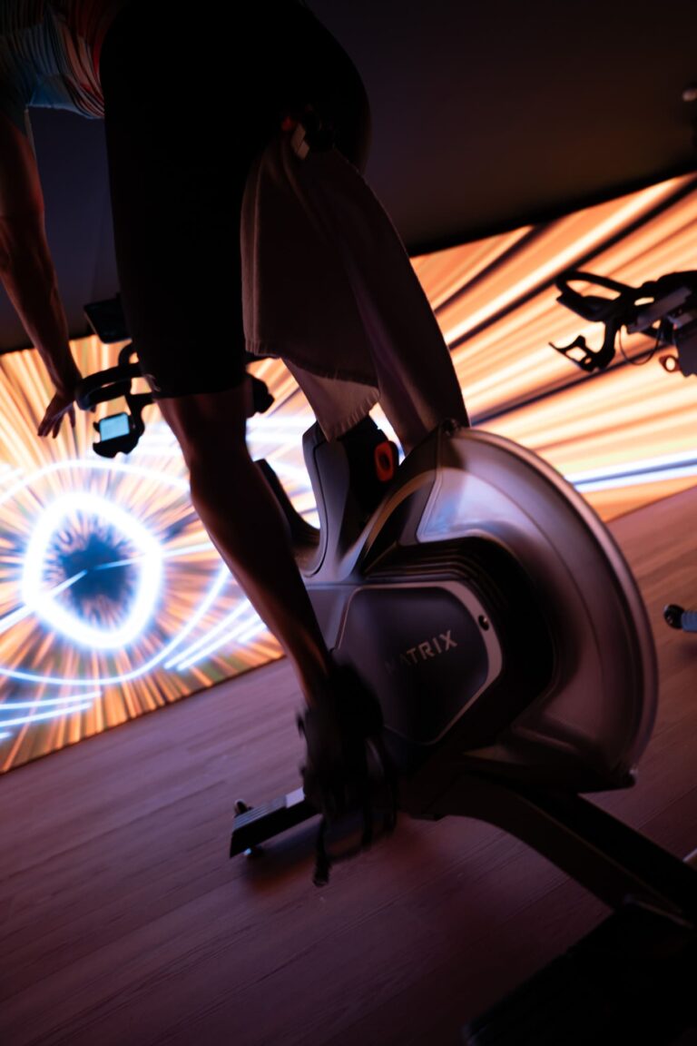 Bicicleta de spinning en un estudio de ciclo indoor con fondo luminoso