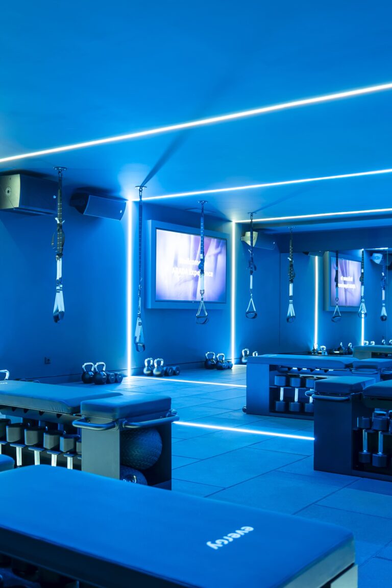 Estudio de entrenamiento con luces LED azules y equipamiento en el suelo